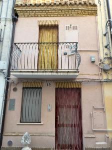 a building with a balcony and a red door at Vicolo Elegante in Ortona