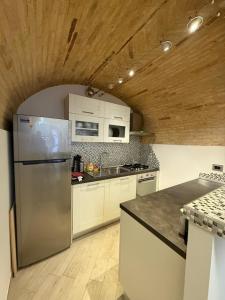 a kitchen with a stainless steel refrigerator and wooden ceilings at Vicolo Elegante in Ortona