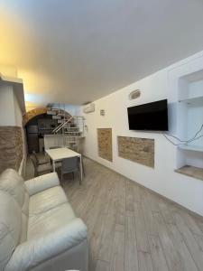 a living room with a couch and a tv on a wall at Vicolo Elegante in Ortona