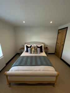 a bedroom with a large bed with two pillows at Evergreen Cottage in East Preston