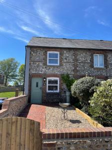 a brick house with a green door at Evergreen Cottage in East Preston