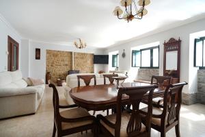 a living room with a dining room table and a couch at Finca A Rochela - Con jardín y ubicación estratégica in Meis
