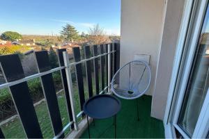 a balcony with a fan and a chair next to a window at Small Bubble in Toulouse, France T2-Parking-1KmMetro-WiFi-Cosy in Ramonville-Saint-Agne