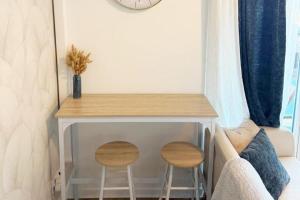 a small table with two stools next to a couch at Small Bubble in Toulouse, France T2-Parking-1KmMetro-WiFi-Cosy in Ramonville-Saint-Agne +13 photos