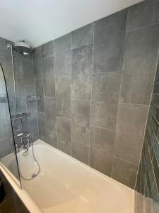 a bathroom with a bath tub and a shower at Evergreen Cottage in East Preston +15 photos