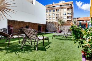 トレビエハにあるApartamentos Madridのパティオ(椅子、芝生の上のテーブル付)