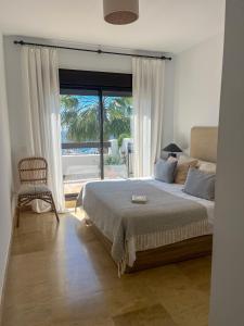 a bedroom with a bed and a large window at Piso Frente al Mar - Marina de Alcaidesa in San Roque +6 photos