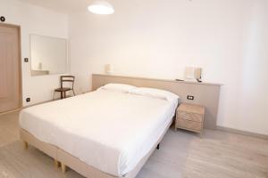 una camera da letto con un grande letto bianco e una sedia di Hotel Europa ad Arma di Taggia