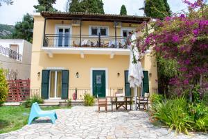 a villa with a patio and a house at Taxi Driver Apartments in Paleokastritsa