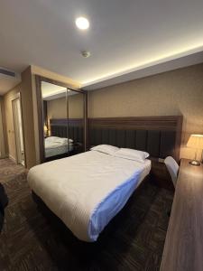 a bedroom with a large bed and a large mirror at Boss Otel Kahramankazan in Kışlaköy