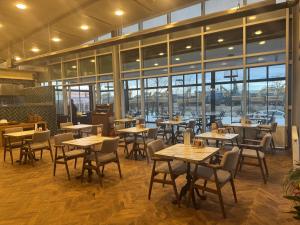 a restaurant with tables and chairs and windows at Boss Otel Kahramankazan in Kışlaköy +11 photos