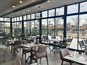 a restaurant with tables and chairs and large windows at Boss Otel Kahramankazan in Kışlaköy