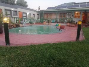 a swimming pool in front of a house at Valleycenter guestlodge in Johannesburg