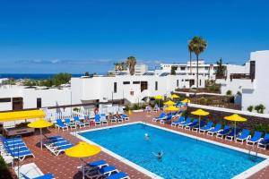 une piscine extérieure avec des parasols et des chaises dans l'établissement Sea Views One bedroom Apartment Paradero near the beach, à Playa de las Americas