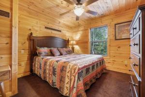 Un dormitorio con una cama en una cabaña de troncos en Bigfoot Bungalow, free tickets, no catch!, en Pigeon Forge