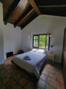 a bedroom with a bed and a window at L'AMAGATALL DEL MONTNEGRE in Villalba Saserra