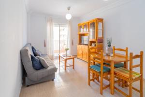 ein Wohnzimmer mit einem Tisch und einem Stuhl in der Unterkunft Piscina y Vistas al Mar Cabo de Palos, Playa Honda in Cabo de Palos