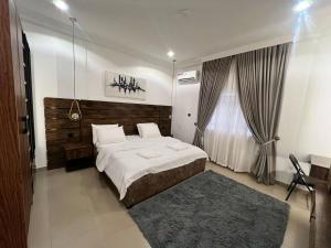 a bedroom with a large bed and a window at Blue Velvet Apartments II in Abuja