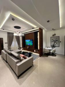 a living room with a couch and a flat screen tv at Blue Velvet Apartments II in Abuja