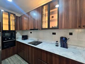 a kitchen with wooden cabinets and a counter top at Blue Velvet Apartments II in Abuja