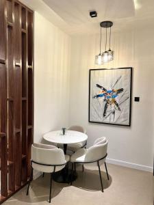 a dining room with a table and chairs and a painting at Blue Velvet Apartments II in Abuja +8 photos