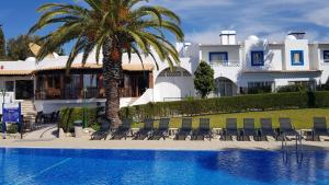 a house with a palm tree and a swimming pool at Pestana Palm Gardens in Carvoeiro