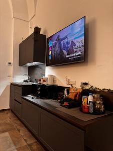 a kitchen with a flat screen tv on the wall at Zephir Green in Brindisi +115 photos