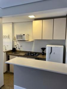 a kitchen with white cabinets and a white refrigerator at Plaza Inn - Brasília Small Town 32 in Sao Paulo