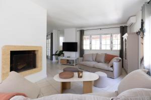 a living room with a couch and a fireplace at Villa Les Mimosas, Fayence in Fayence
