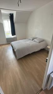 ChaulgnesにあるMaison cosy près du circuit Nevers Magny-Coursのベッドと木の床のある寝室