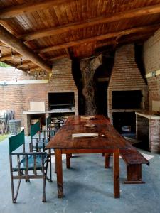 a wooden table and chairs in front of a fireplace at Cabañas Costa Santino in Ituzaingó