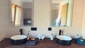 Un baño con dos lavabos y un espejo. en Les Carroz de Mary - Sommand, en Mieussy