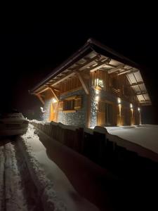 un edificio en la nieve por la noche en Les Carroz de Mary - Sommand, en Mieussy