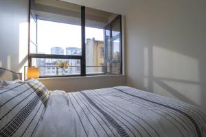 a bedroom with a bed and a large window at Beautiful Downtown Unit in Vancouver