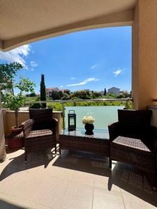 a patio with two chairs and a table with a view at Apartments Toma in Novalja