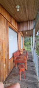 a porch of a building with a bench and a screen at Cabaña con vistas al bosque de Platanillo y al océano Pacífico in Magnolia