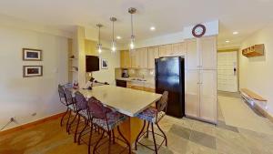 een keuken met een koelkast en een tafel en stoelen bij Crestwood 2215 Deluxe 1 Bedroom in Snowmass Village