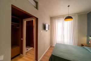 een slaapkamer met een groen bed en een raam bij A Due Passi dal Mare Stanza N2 in Porto Ercole +4 foto's