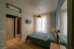 een slaapkamer met een groen bed en een raam bij A Due Passi dal Mare Stanza N2 in Porto Ercole