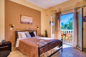 una camera da letto con un letto e una porta scorrevole in vetro di Stefanias Prasoudi Beach ad Ágios Matthaíos