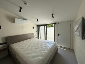 a bedroom with a white bed and a sliding door at Arıcan suite in Eskiömerler