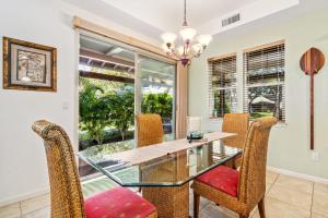 a dining room with a glass table and chairs at Big Island Fairways at Mauna Lani 1701 by Coldwell Banker Island Vacations in Waikoloa +35 photos