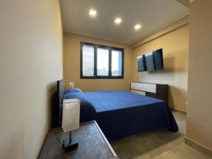 a bedroom with a blue bed and a television at Romano's Ville&Apartaments in Fleri +87 photos