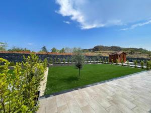 a garden with a green lawn and a fence at Romano's Ville&Apartaments in Fleri