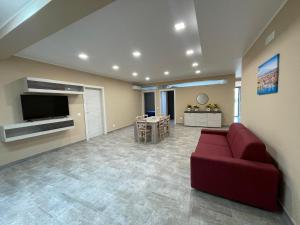 a living room with a red couch and a television at Romano's Ville&Apartaments in Fleri