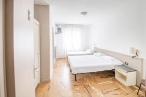 una stanza bianca con un letto e una finestra di Hotel Europa ad Arma di Taggia