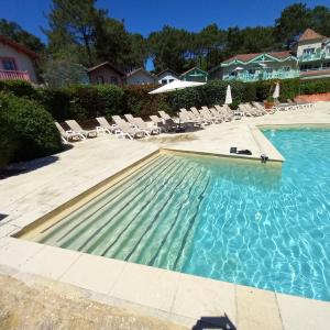 einem Pool mit Liegestühlen und einem Resort in der Unterkunft T2 32m2 terrasse 8m2 PISCINE LACANAU OCEAN LAC GOLF MULTISPORT in Lacanau-Océan
