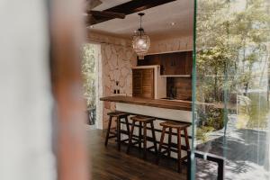 a kitchen with a counter and stools in a room at Tulum Jungle Villa Agua in Chemuyil
