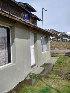 ein kleines Haus mit einem Fenster und einer Tür in der Unterkunft Alojamiento FARAH in Caviahue