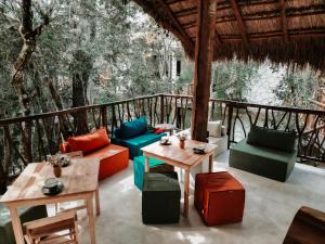 Un patio con mesas y sillas y árboles. en Tulum Jungle Villa Fuego, en Chemuyil